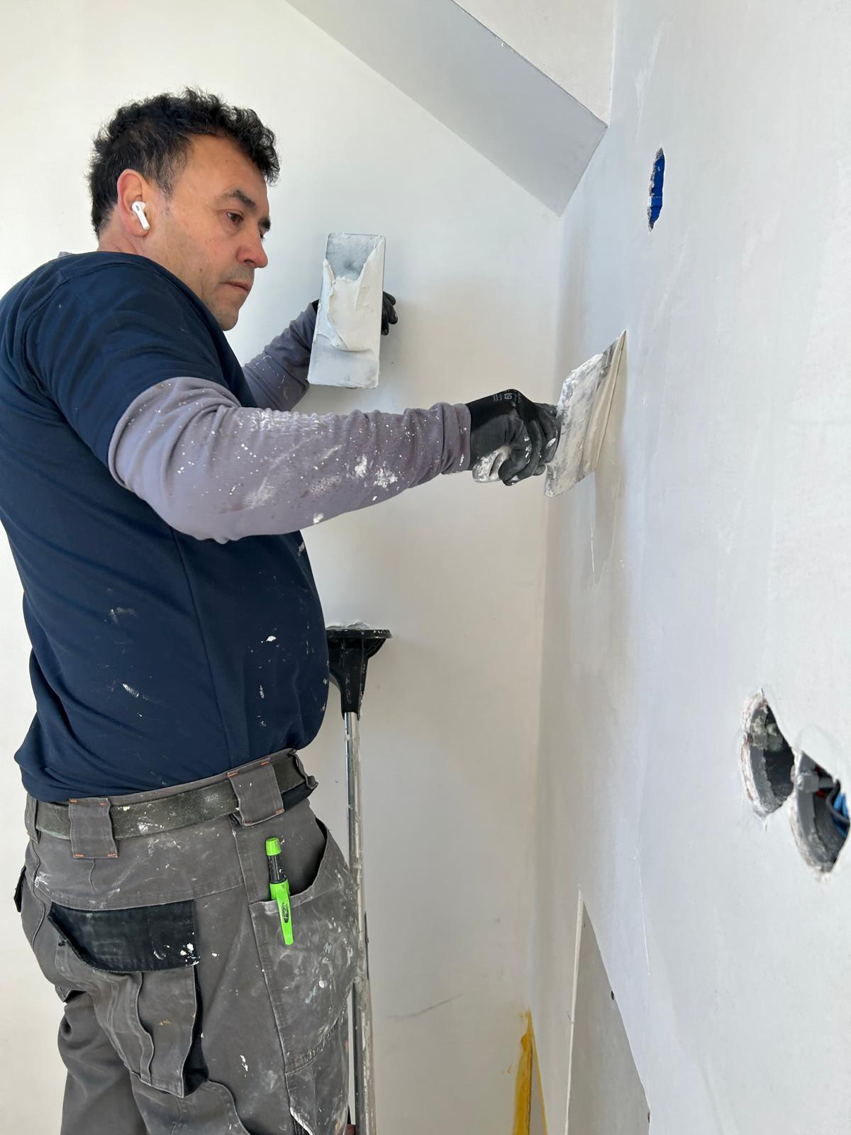 Vakman werkt aan een wand met open aansluitpunten