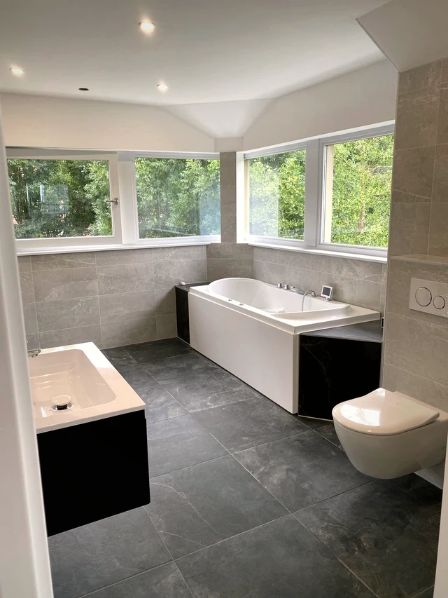 Badkamer met marmerlook tegels en vrijstaand bad